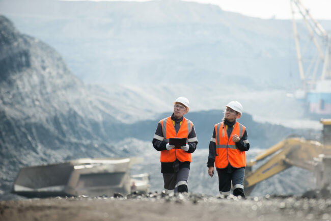 Workers with coal at open pit Two speacialists examining coal at an open pit